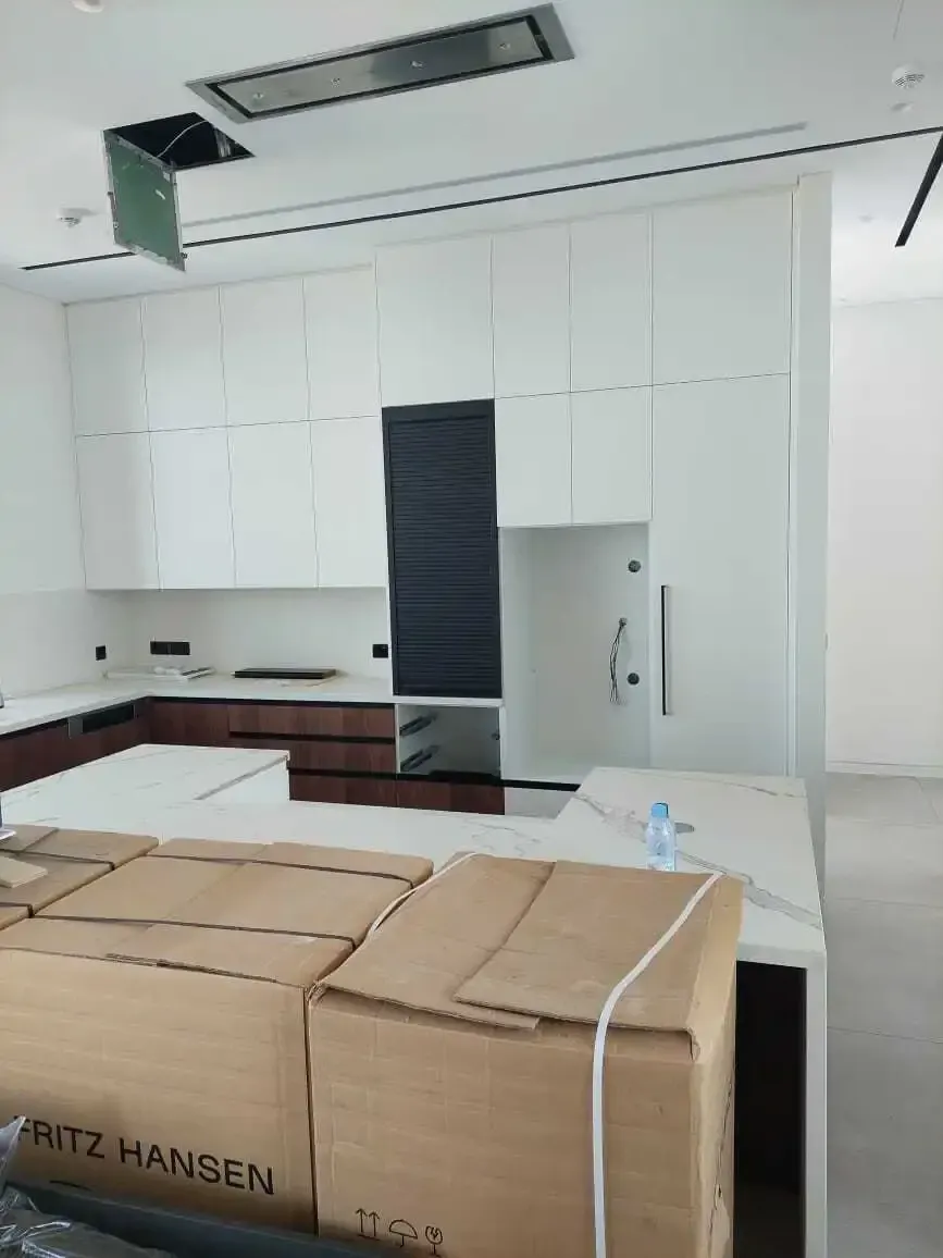 Kitchen during installation, with the island worktop and roller-shutter cabinet in place