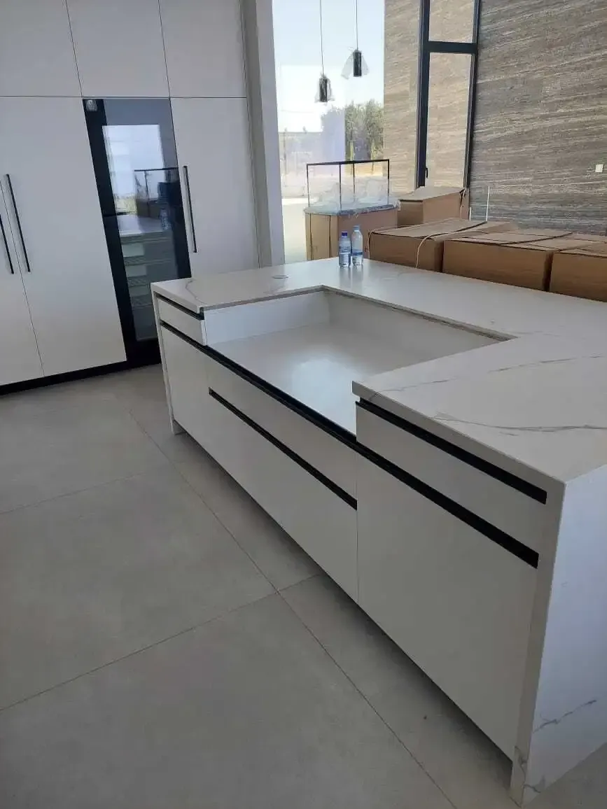 White marble-effect island with black handle grooves during installation