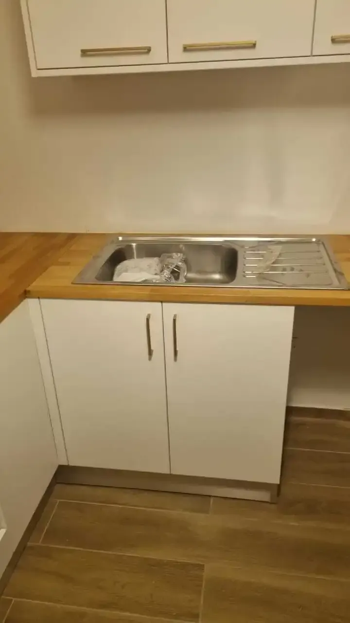 White base units with a wood worktop and inset stainless sink