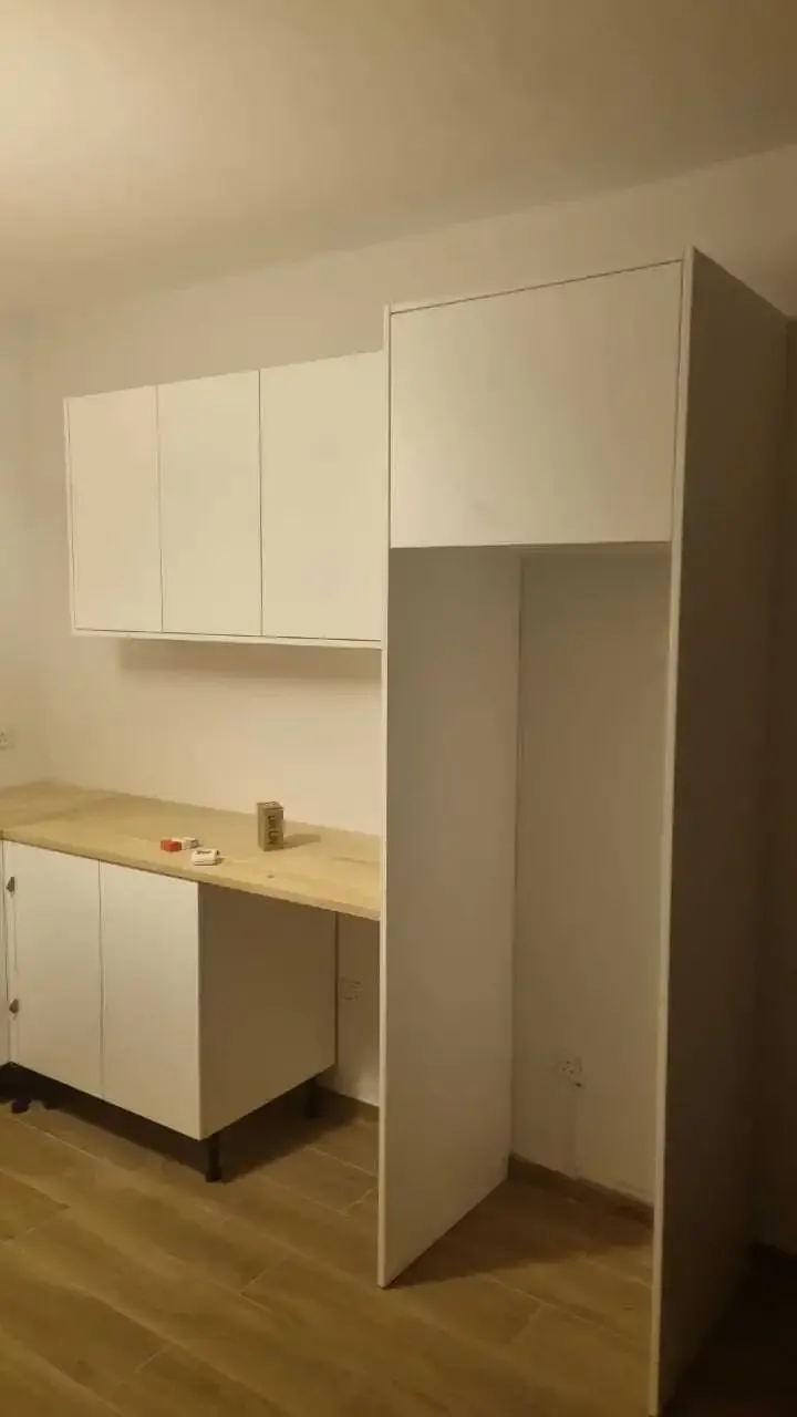 Tall housing unit and white wall cabinets fitted to the ceiling