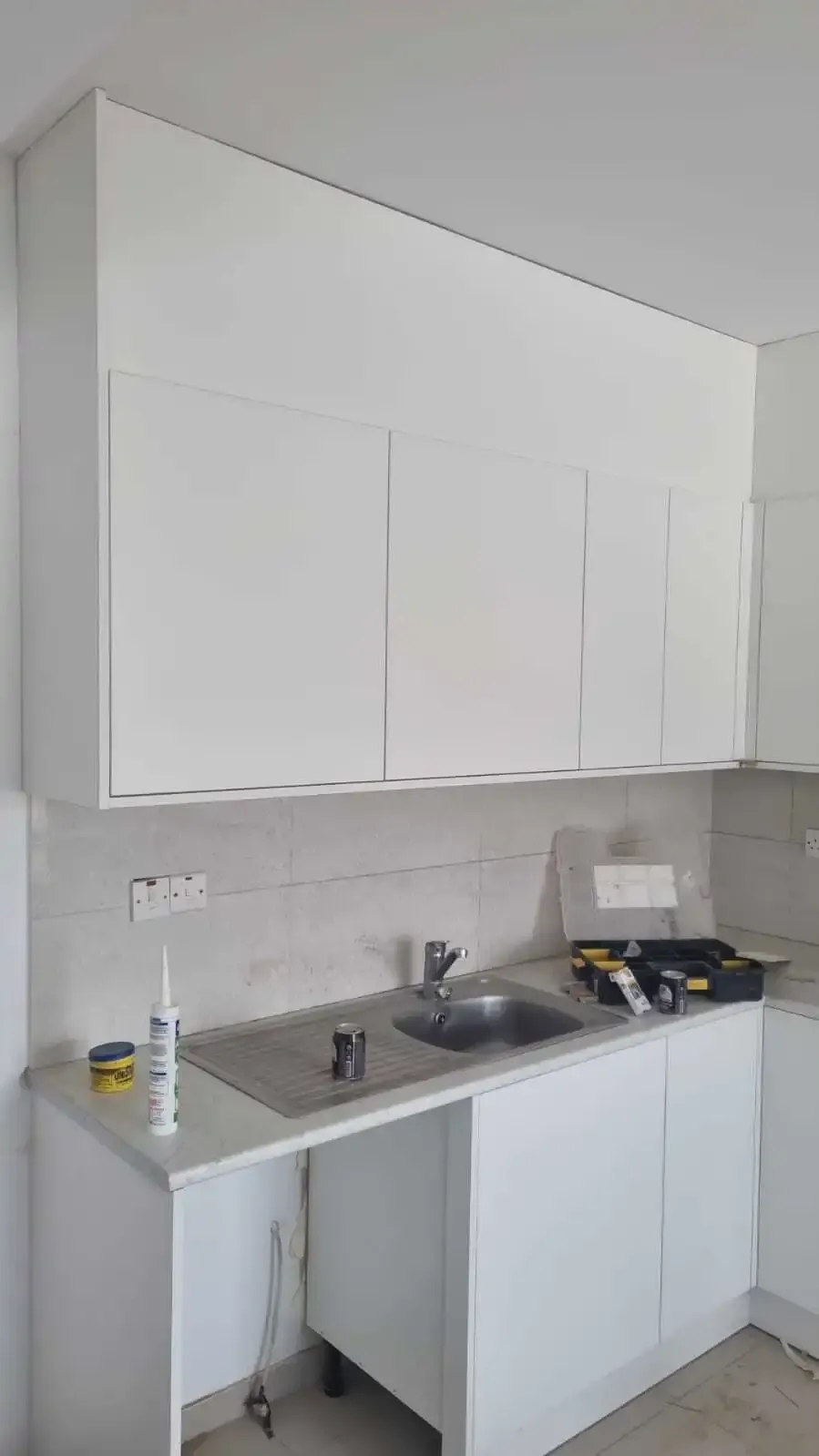 White wall units with an integrated extractor housing above the sink run