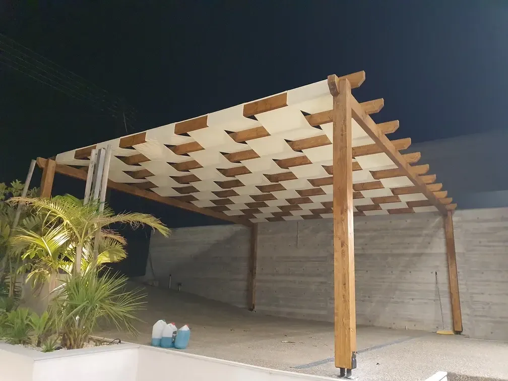 Woven fabric shade threaded through the pergola rafters