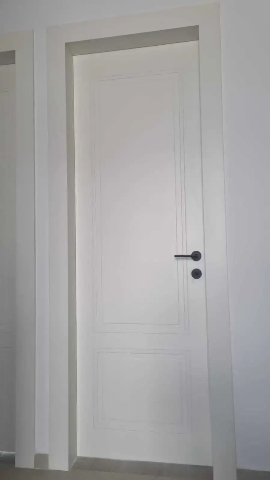 White panelled interior door with a matt black lever handle