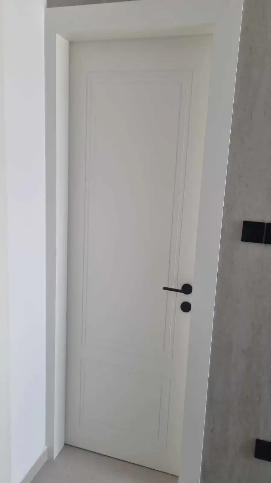 Moulded panel detail of the white door and black hardware