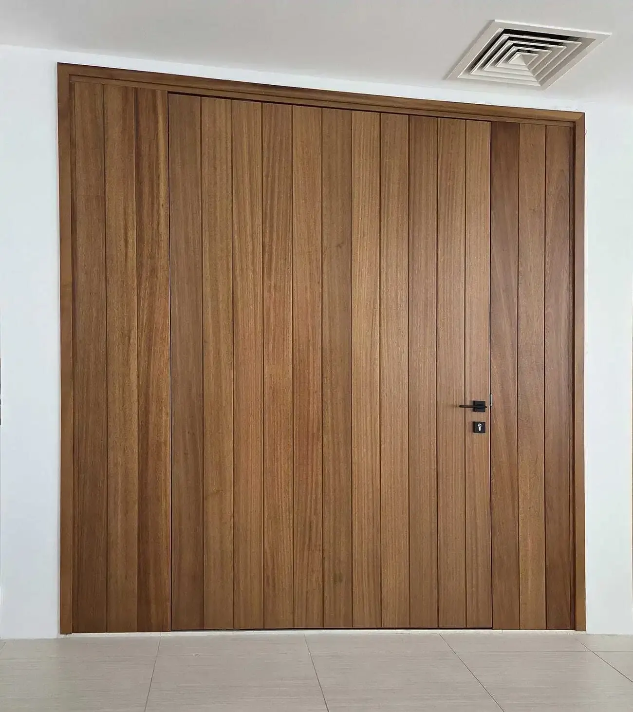 The closed iroko pivot door with vertical boards and matching side panels